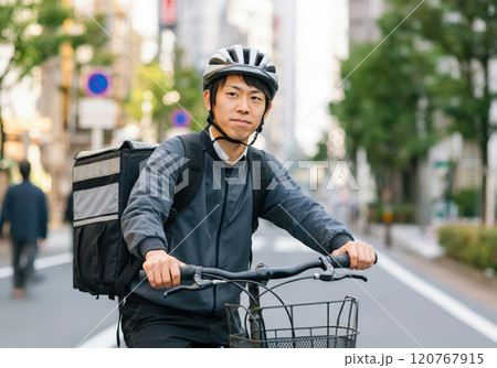 フードデリバリーの仕事を自転車で行う青年 120767915