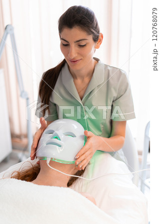 Cosmetologist using modern hydrafacial mask on Cosmetologist using modern hydrafacial mask on 120768079