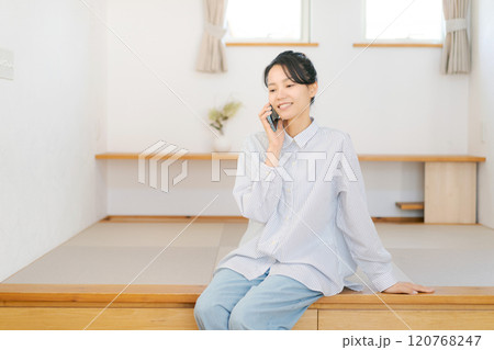 畳の小上がりに座り電話をする女性 畳の小上がりに座り電話をする女性 120768247