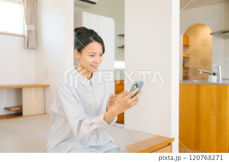 畳の小上がりに座りくつろぐ女性 120768271