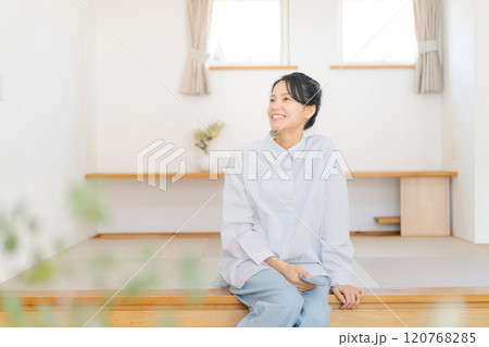 畳の小上がりに座りくつろぐ女性 120768285