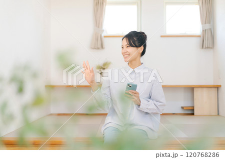 畳の小上がりに座りくつろぐ女性 畳の小上がりに座りくつろぐ女性 120768286