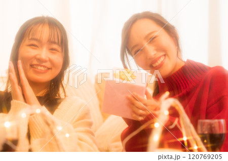 ホームパーティでプレゼントを渡す二人の女性　 120769205