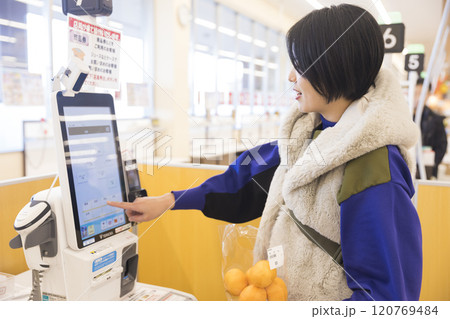 セルフレジでみかんを買う若い女性 120769484