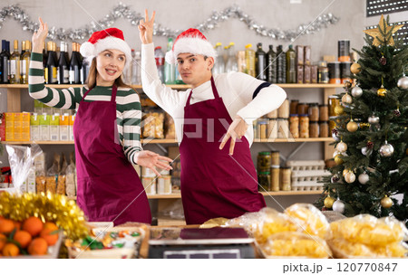 Two funny vendors in Santa Claus perform various funny acrobatic moves in supermarket Two funny vendors in Santa Claus perform various funny acrobatic moves in supermarket 120770847