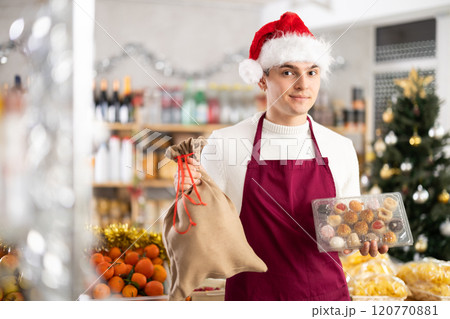 On New Years Eve, sales guy works in store, prepares to celebrate holiday at workplace On New Years Eve, sales guy works in store, prepares to celebrate holiday at workplace 120770881