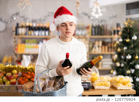 Young guy choosing wine in grocery store 120770924