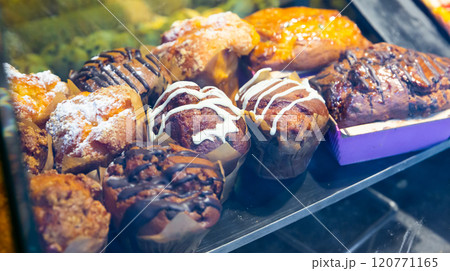 Closeup of various muffins behind glass on display in pastry shop Closeup of various muffins behind glass on display in pastry shop 120771165
