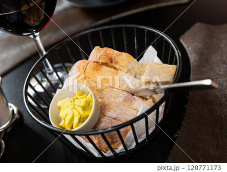 Sliced fresh baked artisan bread with butter in serving basket Sliced fresh baked artisan bread with butter in serving basket 120771173