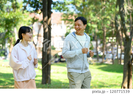 Active senior man and his daughter wearing athletic clothing enjoy their morning run in the fresh air Active senior man and his daughter wearing athletic clothing enjoy their morning run in the fresh air 120771539