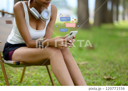 Young woman scrolling through mobile phone with social media notifications while relaxing after her workout Young woman scrolling through mobile phone with social media notifications while relaxing after her workout 120771556