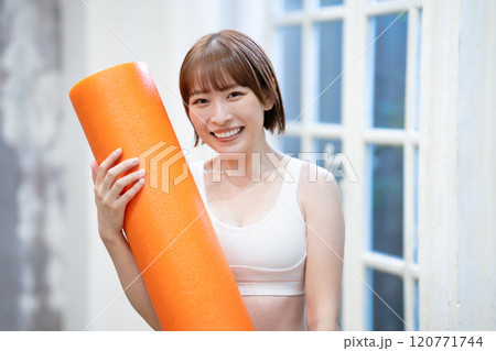ストレッチポールを持つ若い女性 120771744