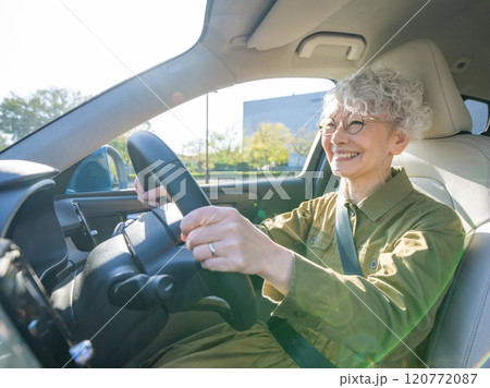 笑顔で自動車を運転するシニア女性 120772087