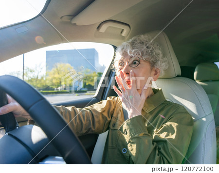 自動車を運転しながらびっくりするシニア女性 自動車を運転しながらびっくりするシニア女性 120772100