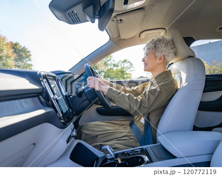 笑顔で自動車を運転するシニア女性 笑顔で自動車を運転するシニア女性 120772119