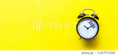 2025 and 2024 on black alarm clock on yellow background 120772160