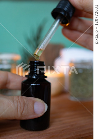 Female hand holding a dropper of essential oil..Closeup Female hand holding a dropper of essential oil..Closeup 120772631