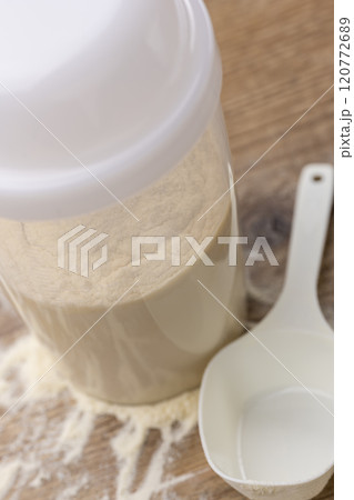 木目テーブルに置かれたプロテインとシェイカー 木目テーブルに置かれたプロテインとシェイカー 120772689