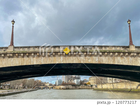 River Seine in Paris, France. Beautiful cityscape with cloudy sky with the view on the houses and bridge from a boat. River Seine in Paris, France. Beautiful cityscape with cloudy sky with the view on the houses and bridge from a boat. 120773217