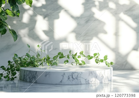 Marble podium with fresh greenery elements placed on a bright surface 120773398