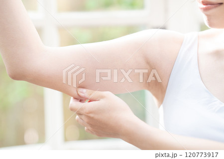 二の腕のたるみを確認する女性【パーツカット】 120773917