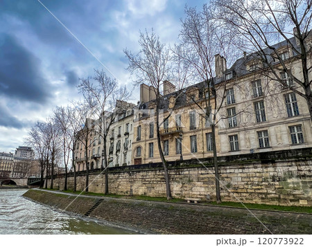 River Seine in Paris, France. Beautiful cityscape with cloudy sky with the view on the houses and bridge from a boat. 120773922