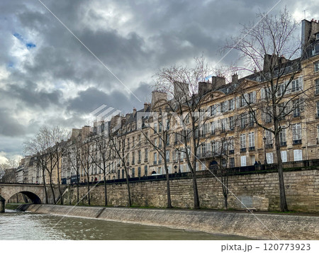 River Seine in Paris, France. Beautiful cityscape with cloudy sky with the view on the houses and bridge from a boat. 120773923