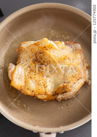フライパンで鶏もも肉のステーキを焼く 120774988