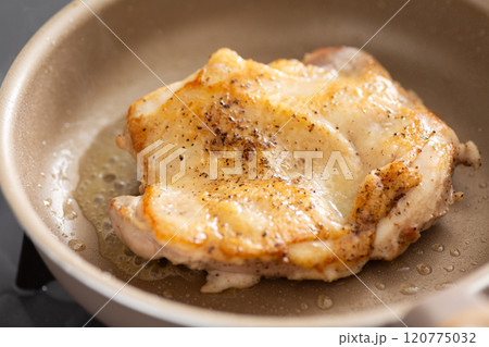 フライパンで鶏もも肉のステーキを焼く 120775032