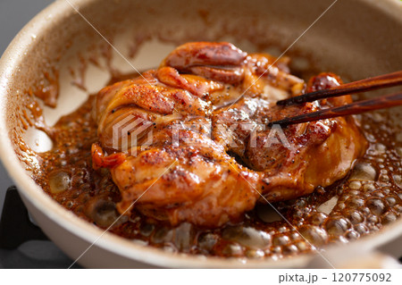 フライパンで鶏もも肉の照り焼きチキンステーキを焼く 120775092