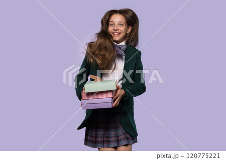Schoolgirl holding colorful gift boxes while smiling. Schoolgirl holding colorful gift boxes while smiling. 120775221