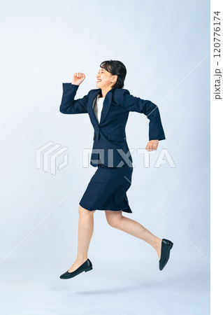 ジャンプするスーツを着た女性の全身写真 120776174
