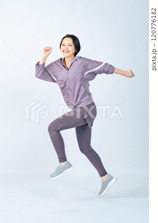 ジャンプするスポーツウェアを着た女性の全身写真 120776182