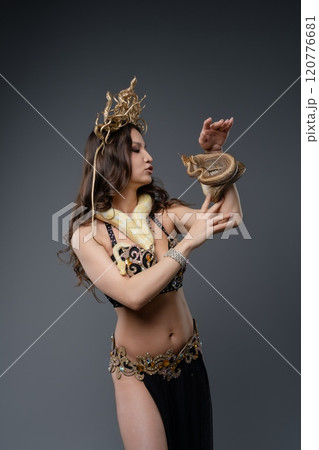 Performer showcases captivating dance with exotic snake in studio setting 120776681