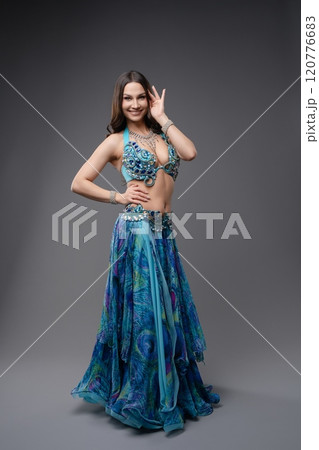 Beautiful dancer showcasing vibrant blue costume in elegant pose indoors 120776683
