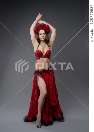 Dancer performing in elegant red costume with floral embellishments Dancer performing in elegant red costume with floral embellishments 120776684
