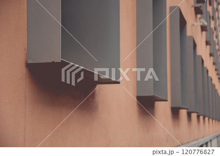 Geometric urban structure of pale brown wall and rows of metal framed windows in dimensional perspective. Modern architecture of Berlin Germany. Details of building exterior 120776827