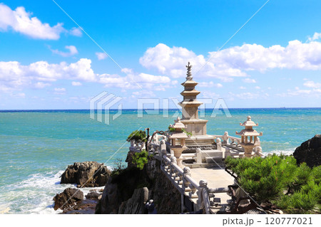 Famous Three-story pagoda on a rocky seashore, Haedong Yonggungsa temple, Busan, South Korea. Sea sceneries of Haedong Yonggung temple with ancient stone pagoda 120777021