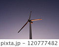 夕日に照らされる風力発電機 120777482