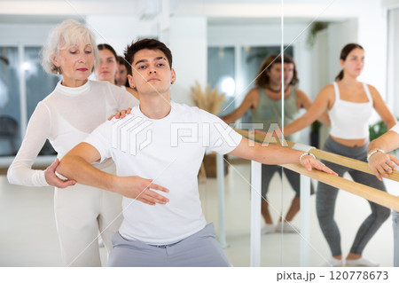 Elderly woman and young boy practicing ballet at barre 120778673