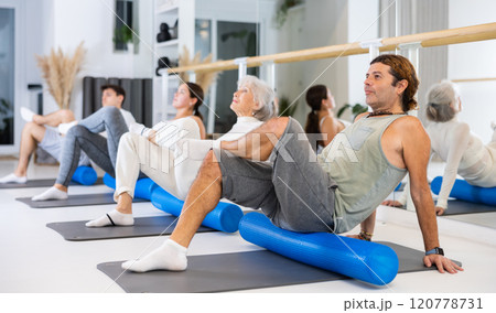 Portrait of people practicing Matsyendrasana known as Lord of Fishes Pose during group yoga training 120778731