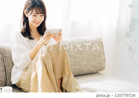 スマホで動画を観る女性 120779726