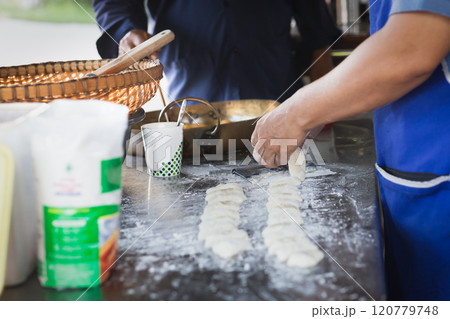 Man making soft dough of chinese doughnut stick before deep-fried. Man making soft dough of chinese doughnut stick before deep-fried. 120779748