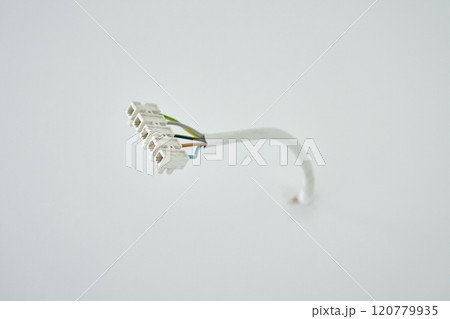 Close-up of electrical wires extending from white wall. Electrical work during apartment renovation. Electricity cable in new apartment 120779935