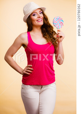 Woman holds colorful lollipop candy in hand 120780162