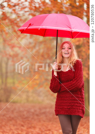 Fashion woman with umbrella relaxing in fall park. 120780536