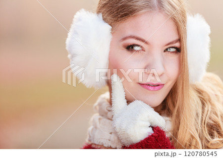 Portrait of suspicious pretty woman in earmuffs Portrait of suspicious pretty woman in earmuffs 120780545