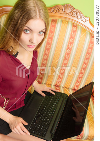 Fashion woman sitting on sofa using pc laptop 120780577