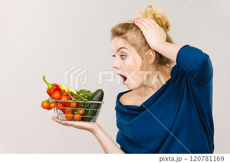Woman with vegetables, shocked face expression Woman with vegetables, shocked face expression 120781169