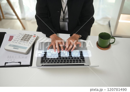 Close up of businesswoman typing on laptop with digital interface icons projected above the keyboard 120781490